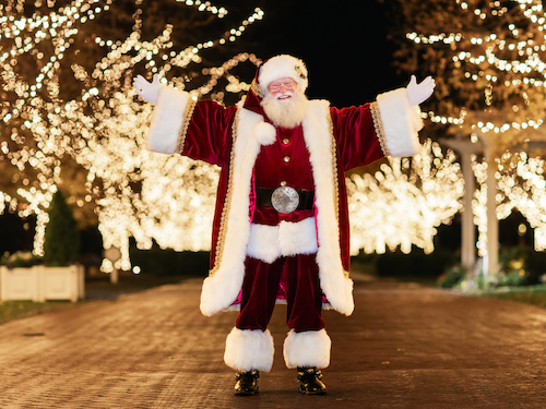 Santa Claus in front of illuminated lights on Watkins Lane